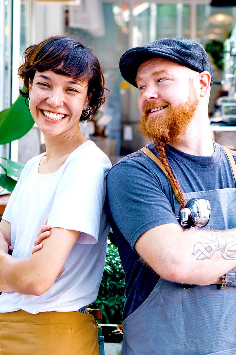 Two small business owners standing back to back