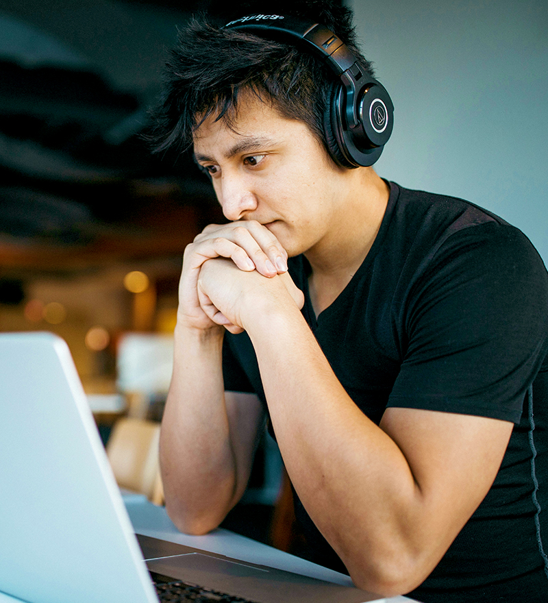 draining-work-img Man wearing headphones at a laptop doing something he is good at but not feeling happy or enjoying his work