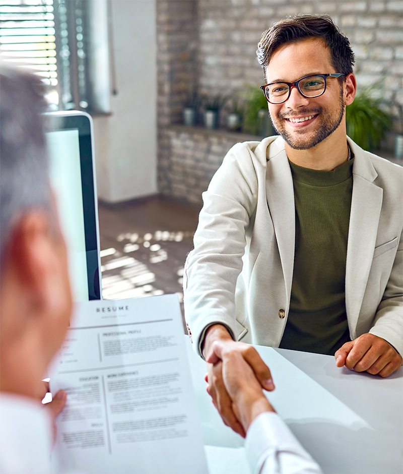 hiring-interview-img A young man being interviewed by an older executive who is holding his resume.