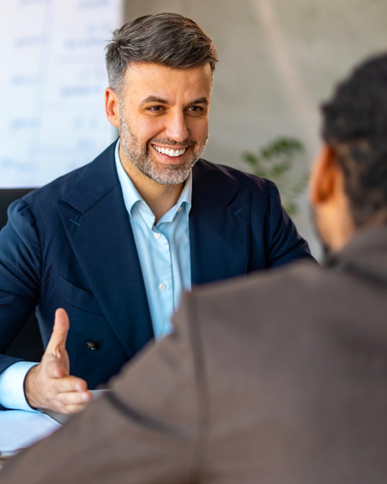 A businessman is ending an interview happy because he identified job fit and made a smart hire