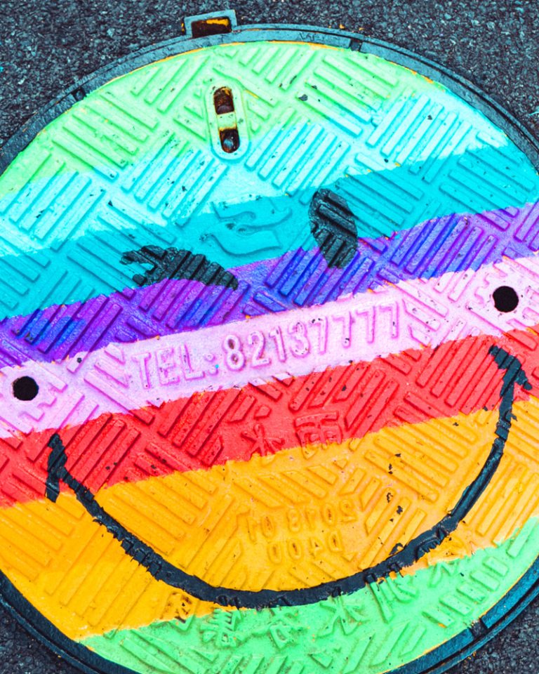 Rainbow smiley face manhole cover