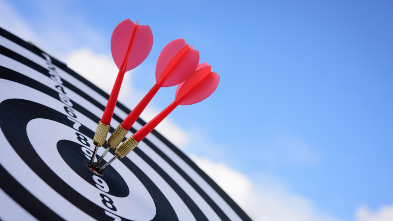 red darts hitting the bullseye