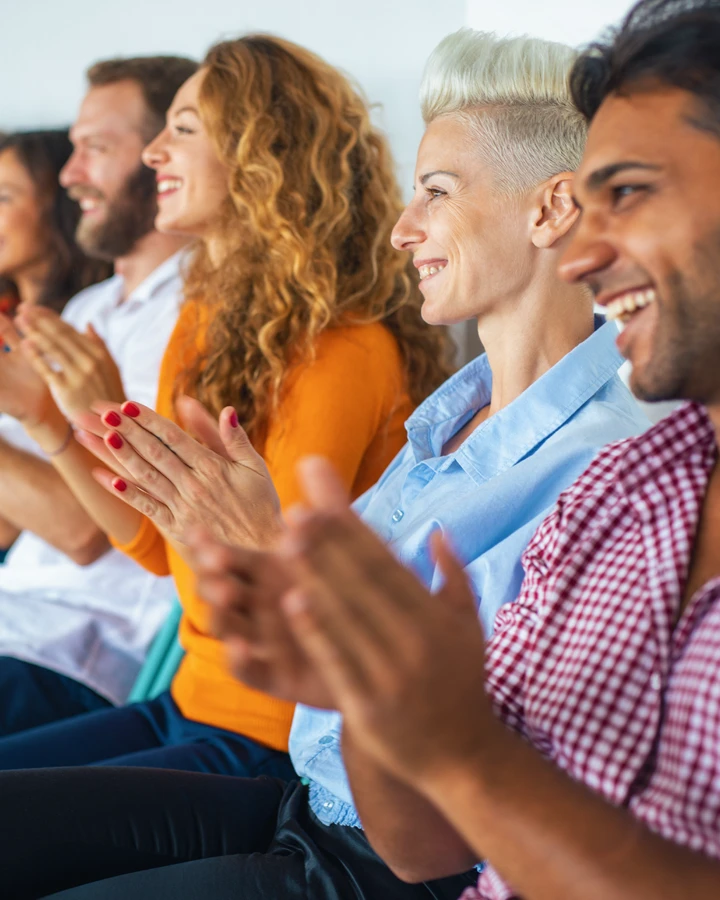 A group of Achievers applauding the success of their peers.