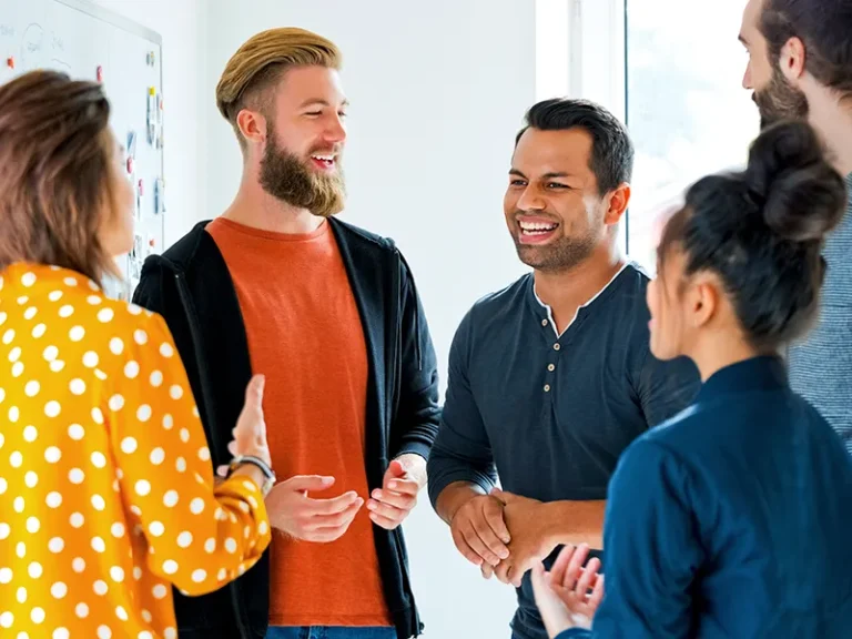 A group of colleagues laughing together while at work