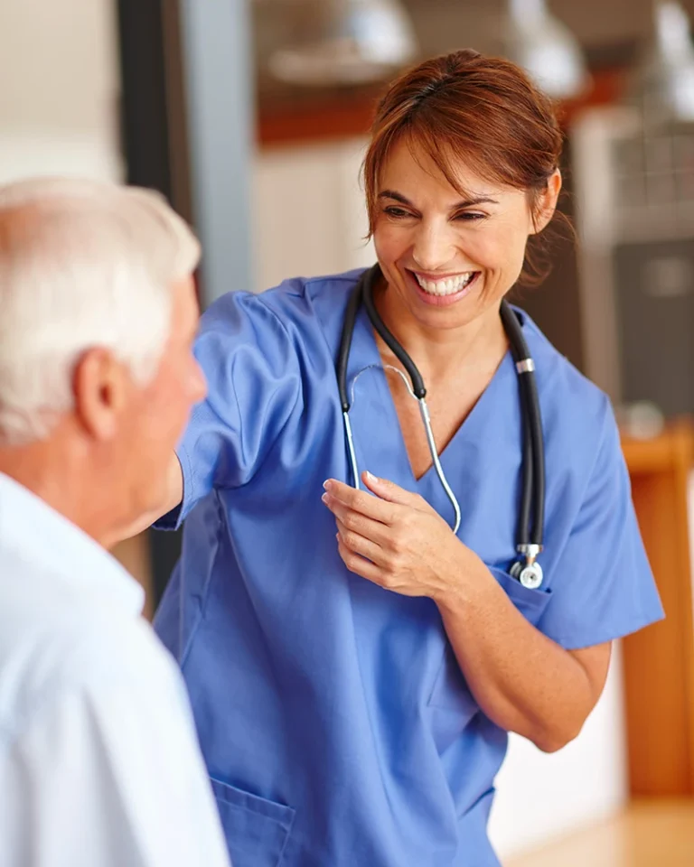 Nurse smiling while helping a patient