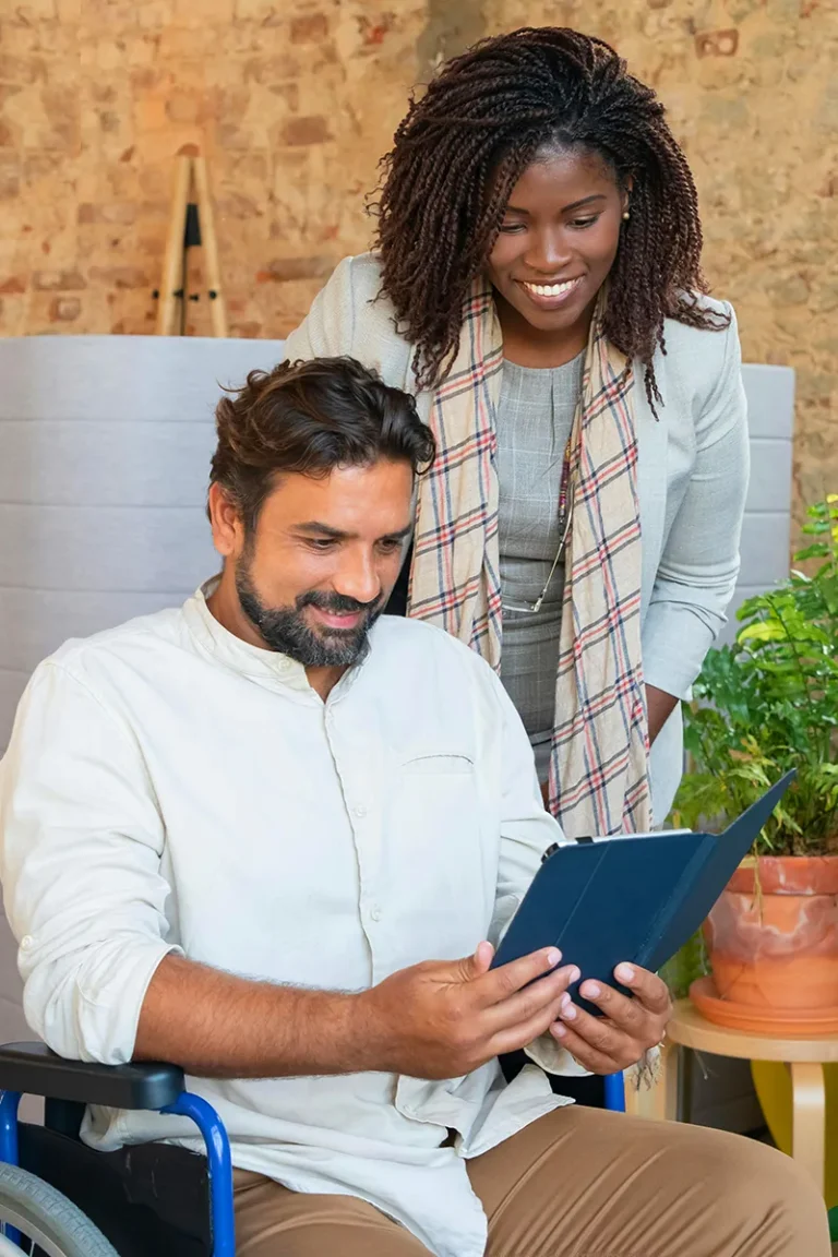Man in a wheelchair and a woman reviewing their MCode results and smiling