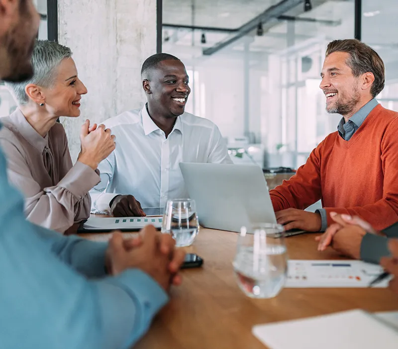 Leaders collaborating and laughing together while at a work meeting.