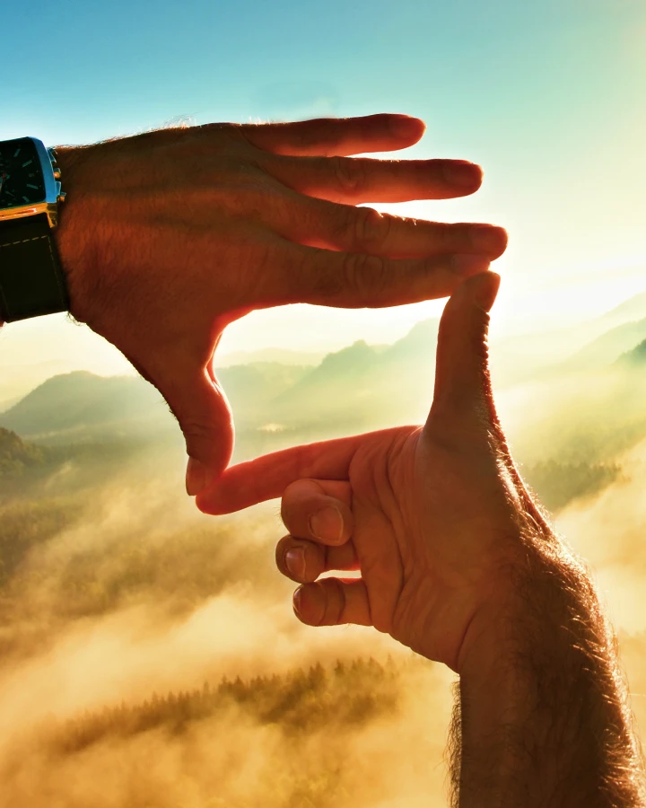 A Visionary framing a scenic landscape with his hands.