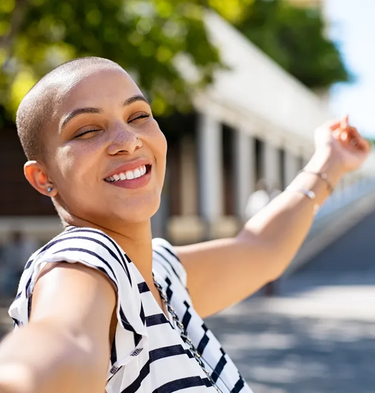 A happy and fulfilled black woman smiling outside
