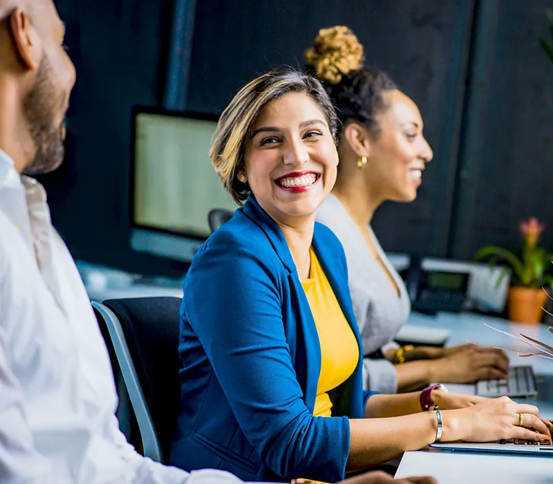 Man and woman working together on their laptops with a positive attitude.